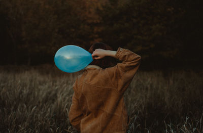 Full length of man holding balloons on field