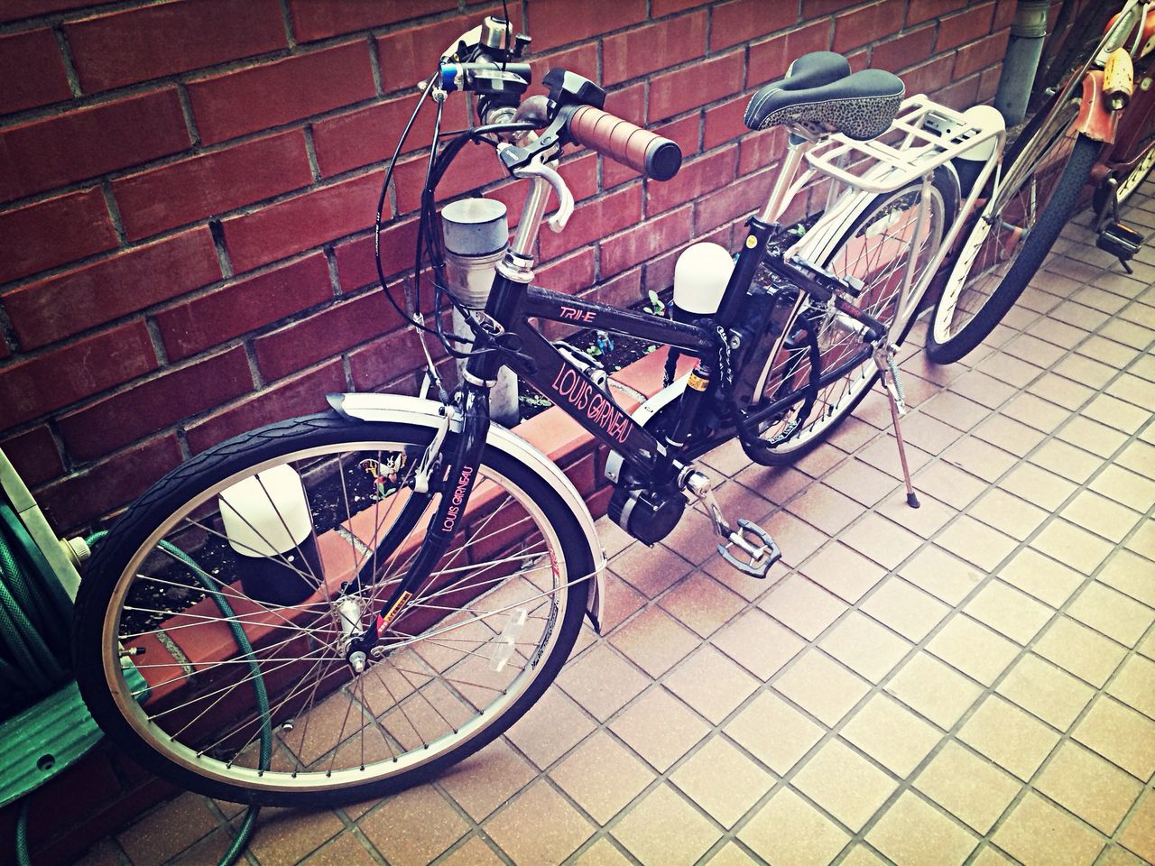 bicycle, transportation, mode of transport, land vehicle, stationary, parking, wheel, parked, street, high angle view, travel, outdoors, motorcycle, day, built structure, sunlight, no people, wall - building feature, shadow, architecture