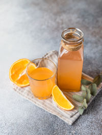 Cold and refreshing fresh orange juice in glass and bottle with fresh orange