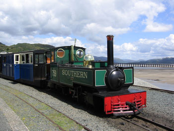 Train by railroad tracks against sky