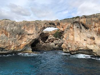 Rock formations by sea against sky