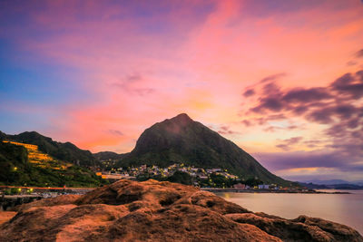 Scenic view of sea against dramatic sky during sunset