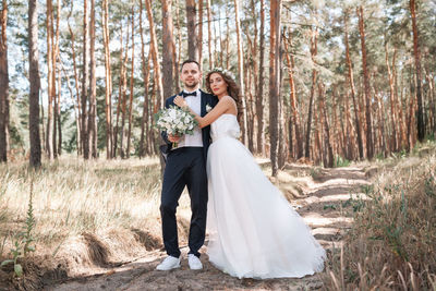 Bride and bridegroom standing on field