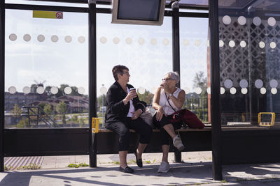 Senior female friends at bus stop