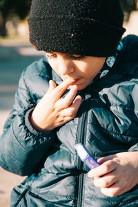 Boy wearing warm clothing and eating candy