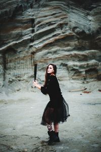 Full length of woman holding baseball bat standing outdoors
