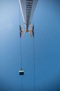 Low angle view of overhead cable car against clear blue sky