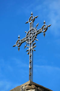 Low angle view of cross against blue sky