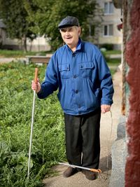 Man wearing hat standing against plants