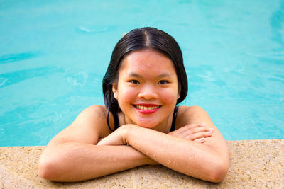 Portrait of asian woman smiling while is into the edge of pool
