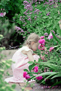 Low angle view of woman with pink flowering plants