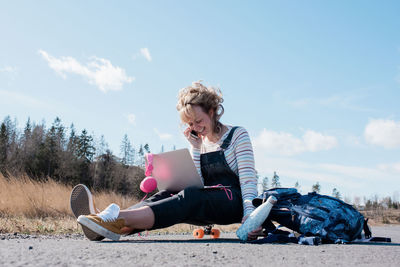 Woman talking on her phone and working on her laptop whilst skating