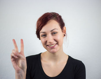 Portrait of smiling young woman against white background