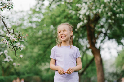 Cute girl laughs loudly outdoors, walking in the park in the spring person