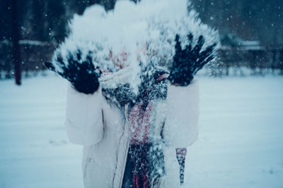 Rear view of woman standing on snow