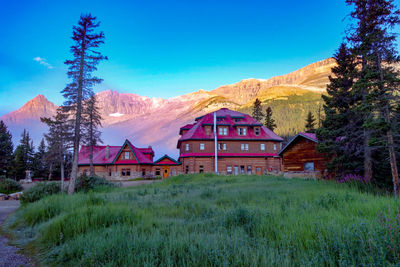 Houses on field by mountain against sky