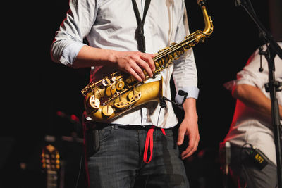 Midsection of man playing guitar