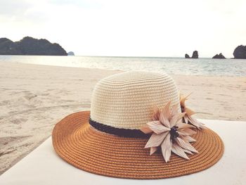 Close-up of hat on beach against sky