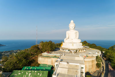 Statue of building by sea against sky