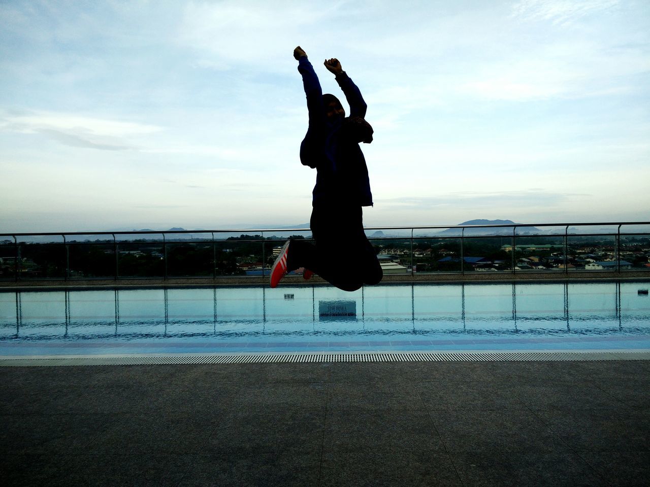 sky, lifestyles, full length, leisure activity, sea, standing, beach, water, cloud - sky, jumping, rear view, freedom, balance, arms raised, men, cloud, arms outstretched, enjoyment