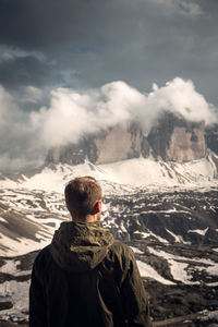 Rear view of man against snowcapped mountains and sky