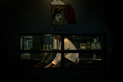 Man standing by glass window at home