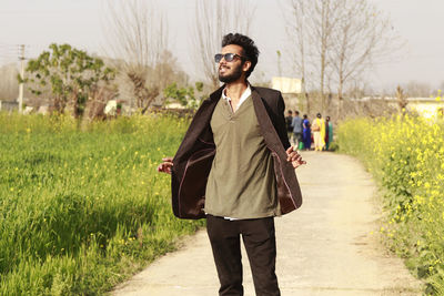 Portrait of young man standing against plants