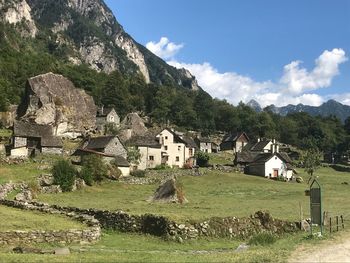 Houses by trees and mountains against sky