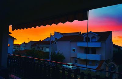 Residential buildings against sky during sunset