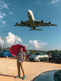 Man with umbrella against sky