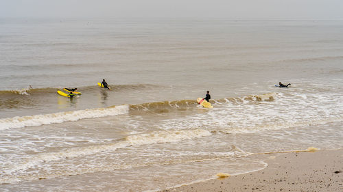 People at beach against sky