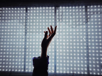 Silhouette of person hand against wall