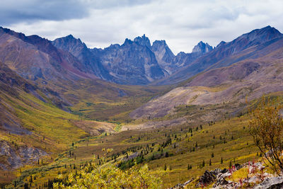 Scenic view of valley and mountains against sky