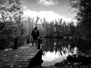 Man standing by lake against sky