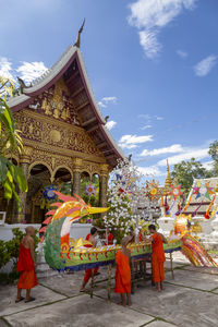 Group of people outside temple against building