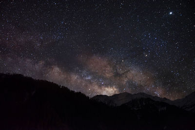 Scenic view of mountains against star field at night