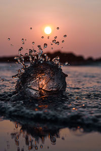 Close-up of sea,water droplets during sunset