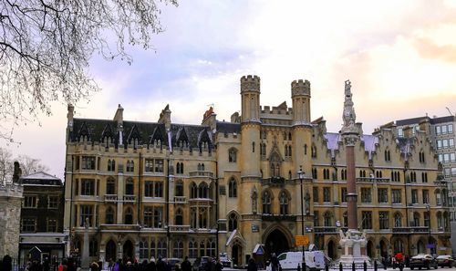 Buildings in city against cloudy sky