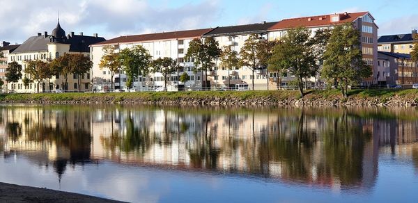 Scenic view of lake by buildings against sky