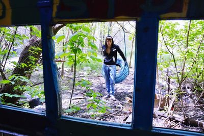 Portrait of woman standing against plants