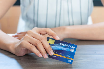 Close-up of woman holding hands with text on table