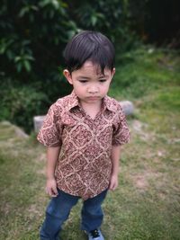Cute boy standing on field