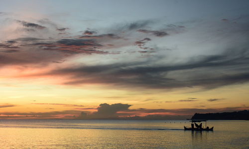 Scenic view of sea against dramatic sky during sunset