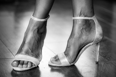 Woman putting on elegant silver sandals