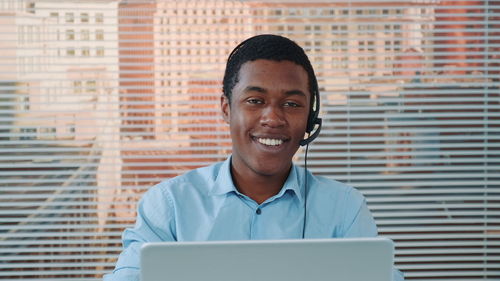 Portrait of smiling young man using mobile phone