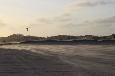 Scenic view of beach against cloudy sky