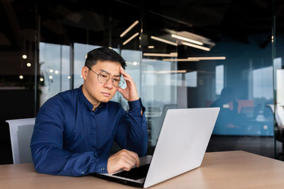 Young man using laptop at table