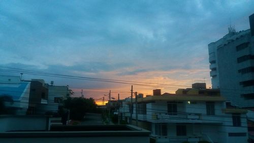 Buildings in city against cloudy sky