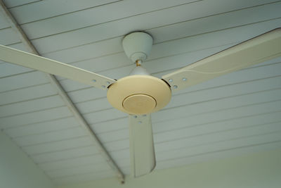 Low angle view of fan hanging from ceiling