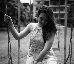 Young woman sitting on swing at playground